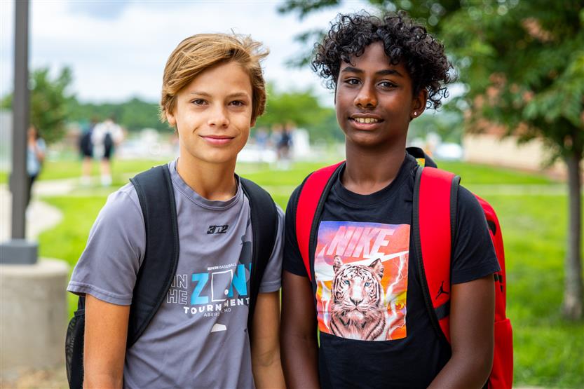Two students smile